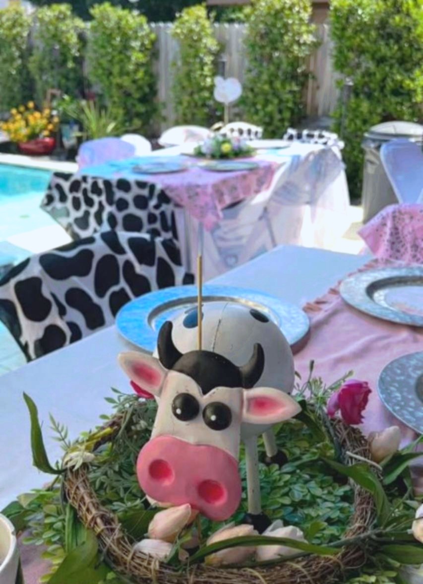 Cow theme outdoor baby shower with cute cow centerpiece floral wreath and pool backdrop at Carissa Venue