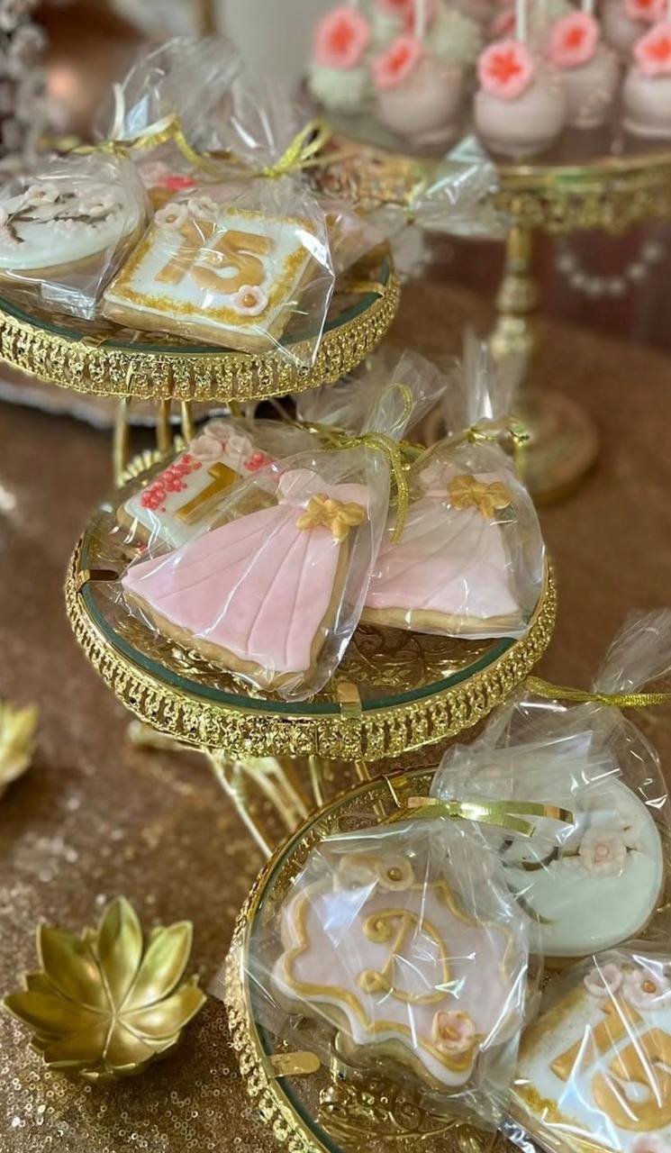 Custom quince cookies on gold tiered stand with dress and 15 designs at Carissa Venue