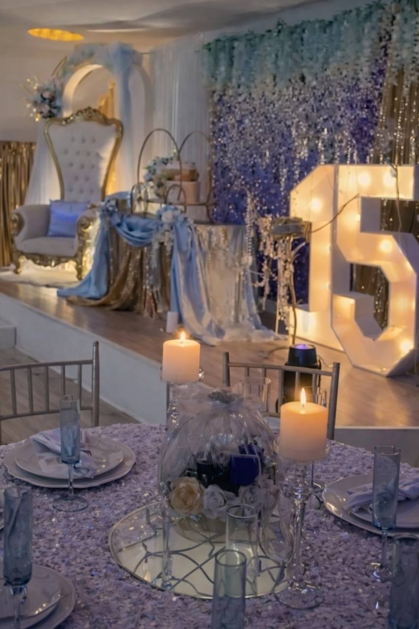 Blue quinceañera reception hall with illuminated 15 marquee and candles at Carissa Venue